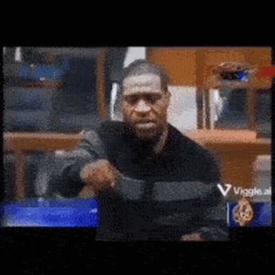 A Blurry Picture Of A Man Holding A Gun In Front Of A Sign That Says Viggle GIF