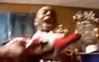A Blurry Picture Of A Man Holding A Red Object In A Room . GIF