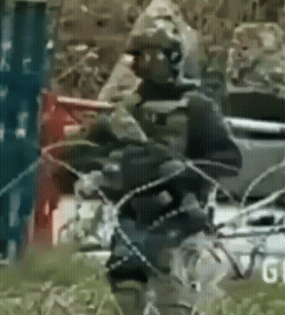 a blurry picture of a man holding a rifle with the word gi on the bottom
