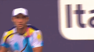 A Blurry Picture Of A Man Holding A Tennis Racquet In Front Of A Sign That Says Lite GIF