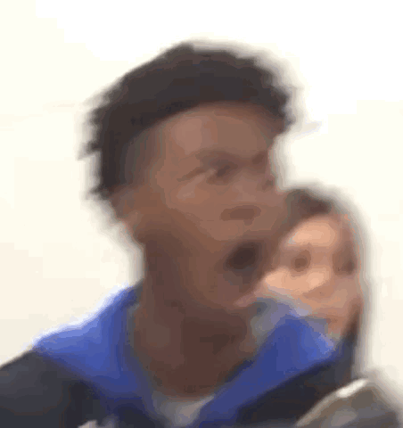 A Blurry Picture Of A Man In A Blue Jacket With His Mouth Open . GIF