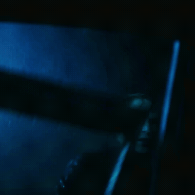 A Blurry Picture Of A Man In A Dark Room With A Blue Background GIF