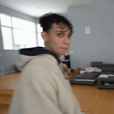 A Blurry Picture Of A Man In A Living Room With A Couch . GIF