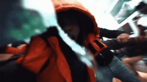 A Blurry Picture Of A Man In A Red Jacket GIF