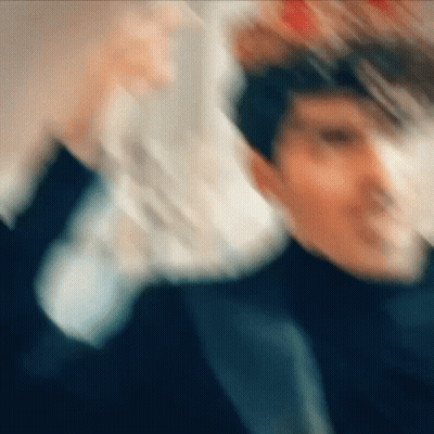 A Blurry Picture Of A Man In A Suit And Tie Holding A Stack Of Money . GIF