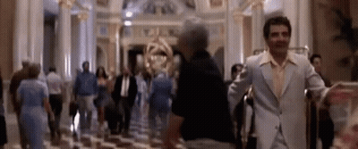 A Blurry Picture Of A Man In A Suit Standing In A Lobby Of A Hotel . GIF