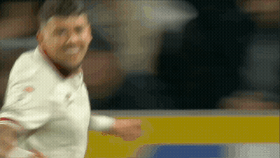 A Blurry Picture Of A Man In A White Shirt Standing In Front Of A Wall GIF