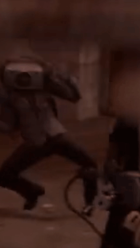 A Blurry Picture Of A Man Running With A Camera On His Shoulder GIF