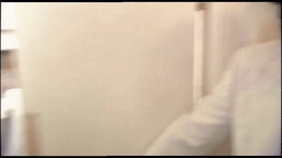 A Blurry Picture Of A Man 'S Face Behind A White Wall . GIF
