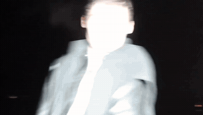 A Blurry Picture Of A Man 'S Face In The Dark GIF