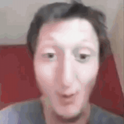 A Blurry Picture Of A Man 'S Face Making A Funny Face While Sitting In A Chair . GIF