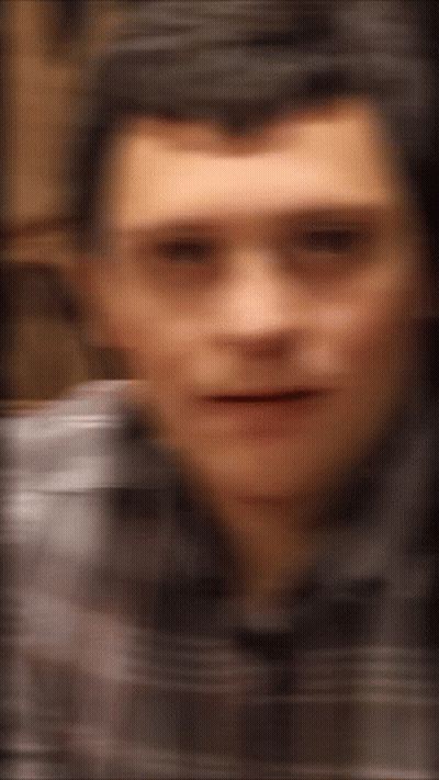 A Blurry Picture Of A Man 'S Face With A Striped Shirt On GIF