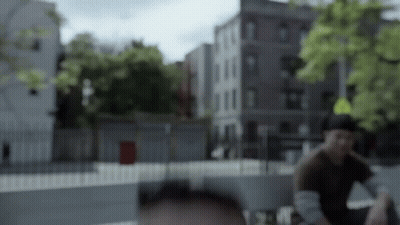 A Blurry Picture Of A Man Sitting In Front Of A Yellow Sign GIF