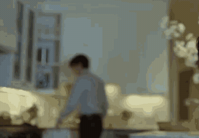 A Blurry Picture Of A Man Standing In A Living Room With A Couch . GIF