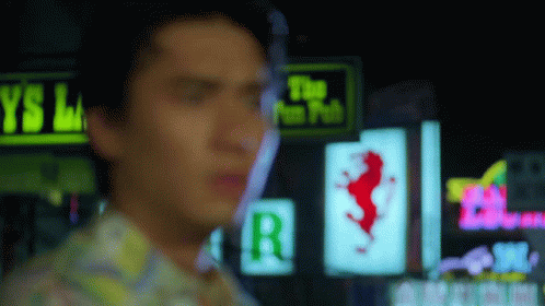 A Blurry Picture Of A Man Standing In Front Of A Neon Sign That Says The Fun Pub GIF