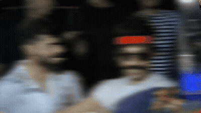 A Blurry Picture Of A Man Standing In Front Of A Red Light GIF
