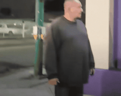 A Blurry Picture Of A Man Standing In Front Of A Store GIF
