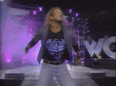 A Blurry Picture Of A Man Standing In Front Of A Wow Sign GIF