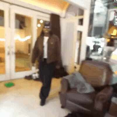 A Blurry Picture Of A Man Walking In A Living Room GIF