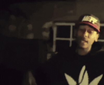A Blurry Picture Of A Man Wearing A Hat And A Black Jacket . GIF