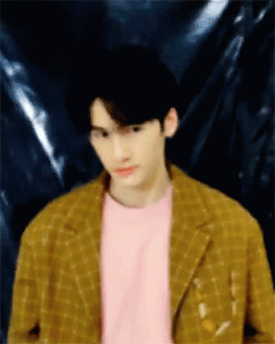 A Blurry Picture Of A Man Wearing A Pink Shirt And A Yellow Jacket GIF