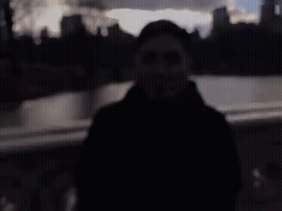 A Blurry Picture Of A Man Wearing Sunglasses And A Black Coat . GIF