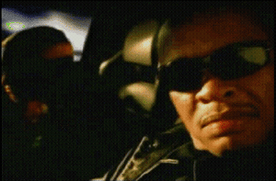A Blurry Picture Of A Man Wearing Sunglasses And A Green Shirt GIF