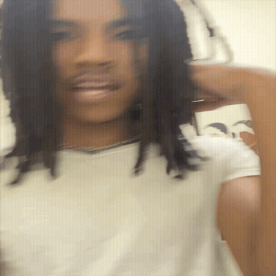 A Blurry Picture Of A Man With Dreadlocks GIF