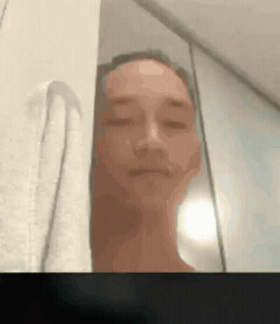 A Blurry Picture Of A Man With His Eyes Closed And A Towel Behind Him GIF