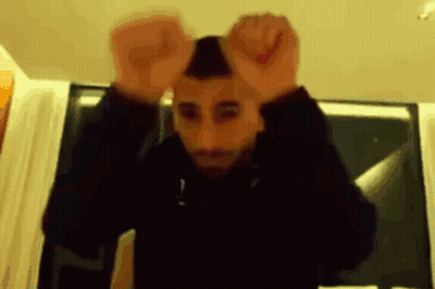A Blurry Picture Of A Man With His Hands Up In The Air GIF