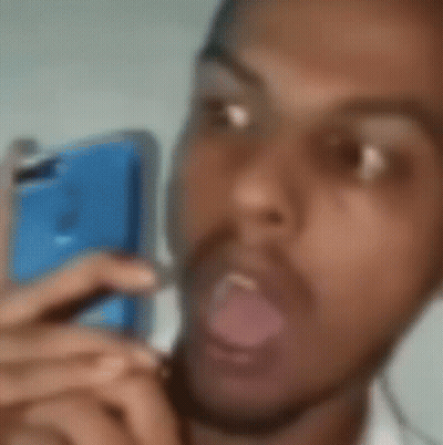 A Blurry Picture Of A Man With His Mouth Open And His Tongue Out . GIF