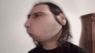 A Blurry Picture Of A Man With Long Hair And A Beard GIF