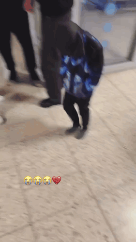 A Blurry Picture Of A Person Carrying A Bag With A Heart And Three Crying Faces On It GIF