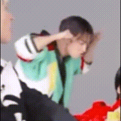 A Blurry Picture Of A Person Covering Their Ears With Their Hands . GIF