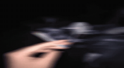 A Blurry Picture Of A Person Holding A Cigarette In Their Hand . GIF