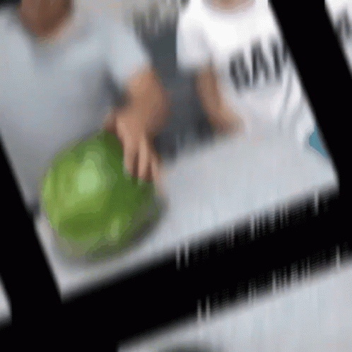 A Blurry Picture Of A Person Holding A Green Ball GIF