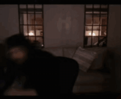 A Blurry Picture Of A Person Holding A Remote Control In A Dark Room . GIF