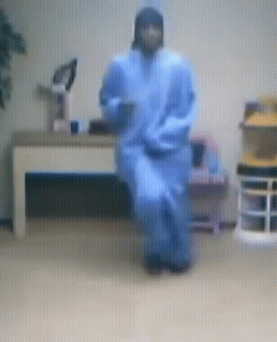 A Blurry Picture Of A Person In A Blue Robe Dancing In A Room GIF