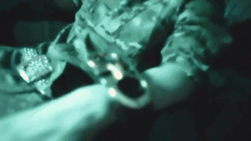A Blurry Picture Of A Person In A Military Uniform Holding A Remote Control GIF