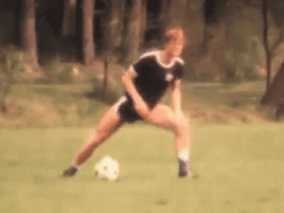 A Blurry Picture Of A Person Kicking A Soccer Ball On A Field GIF