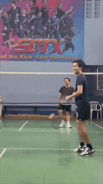 A Blurry Picture Of A Person Playing Badminton With A Picture Of A Bird On The Wall Behind Them GIF