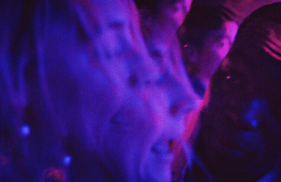 A Blurry Picture Of A Person 'S Back With Purple And Blue Lights Behind Them GIF