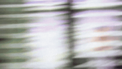 A Blurry Picture Of A Person 'S Face Behind Blinds GIF
