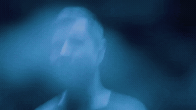 A Blurry Picture Of A Person 'S Face In A Blue Light GIF