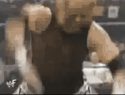 A Blurry Picture Of A Person 'S Face With A Wrestling Logo On The Bottom Right Corner . GIF