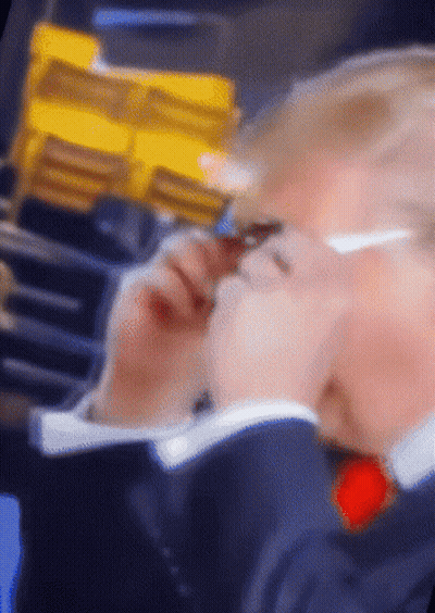 A Blurry Picture Of A Person 'S Face With A Yellow Item In The Background GIF