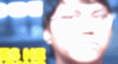 A Blurry Picture Of A Person 'S Face With A Yellow Sign In The Background That Says ' Snm ' GIF