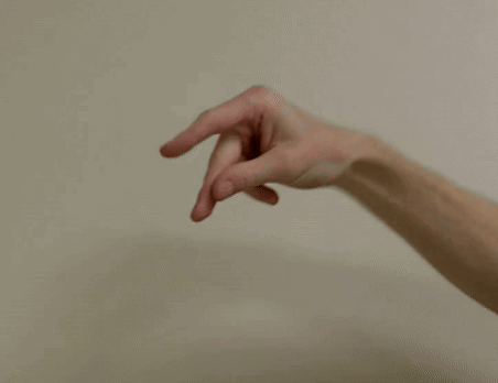 A Blurry Picture Of A Person 'S Hand Reaching Out Towards A White Wall . GIF