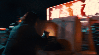 A Blurry Picture Of A Person Sitting In Front Of A Sign That Says ' Hong Kong ' On It GIF