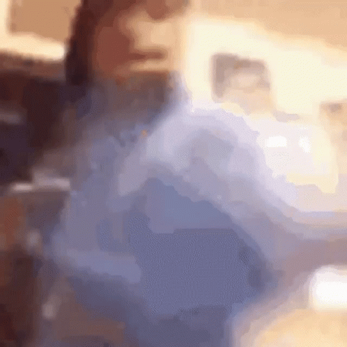 A Blurry Picture Of A Person Sitting On A Couch In A Living Room . GIF